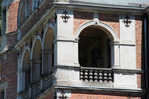 Fragment balkonu z czterema łukami w pałacu w Kobylnikach widziany z boku w dzień.